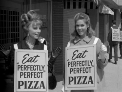 Endora and Samantha wear sandwich boards to advertise Perfect Pizza