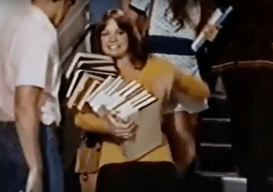 Alice carries stack of books, Room 222